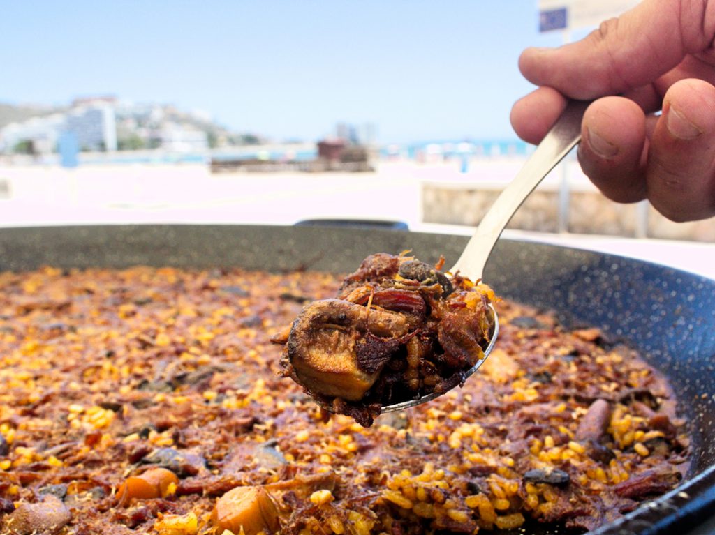 Arroz con carne servido en paellera en la terraza de Restaurante Aruba