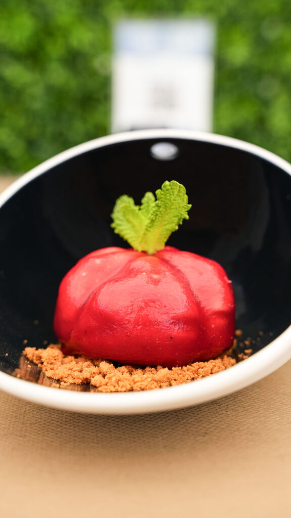 Postre de mousse roja con menta servido en la terraza