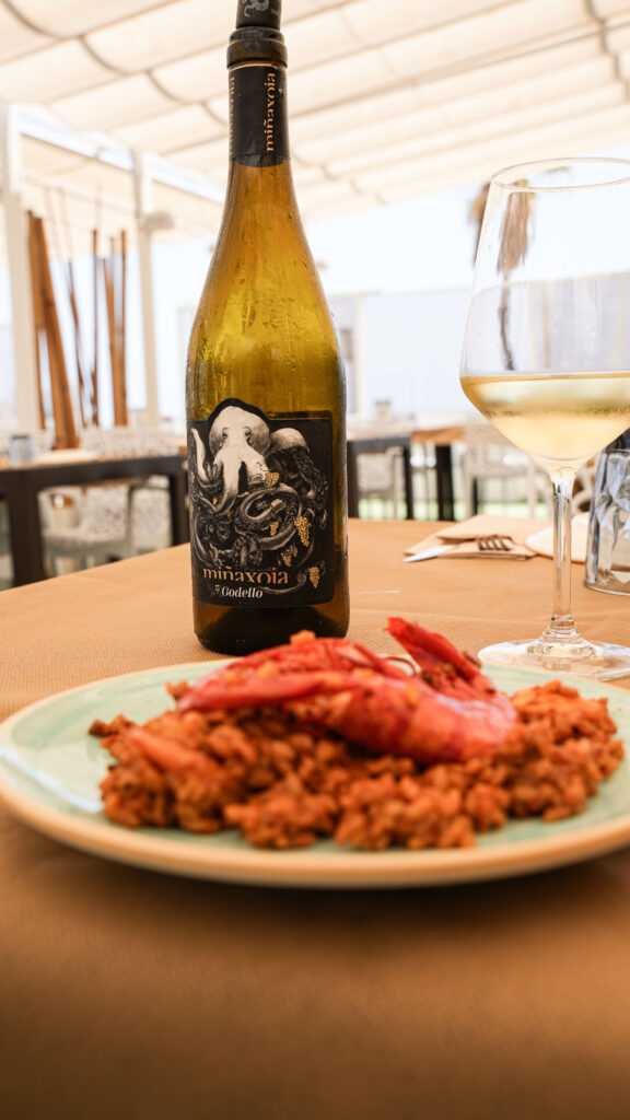 Arroz con gambas y copa de vino blanco en la terraza del restaurante